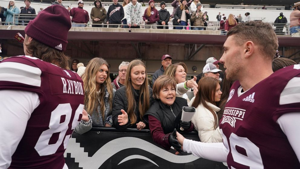 Mississippi State placekicker Massimo Biscardi, right, reaches out to receive congratulatory handshakes from attendees in the Mississippi State Gridiron Club after Mississippi State's win in an NCAA college football game against East Tennessee State,
