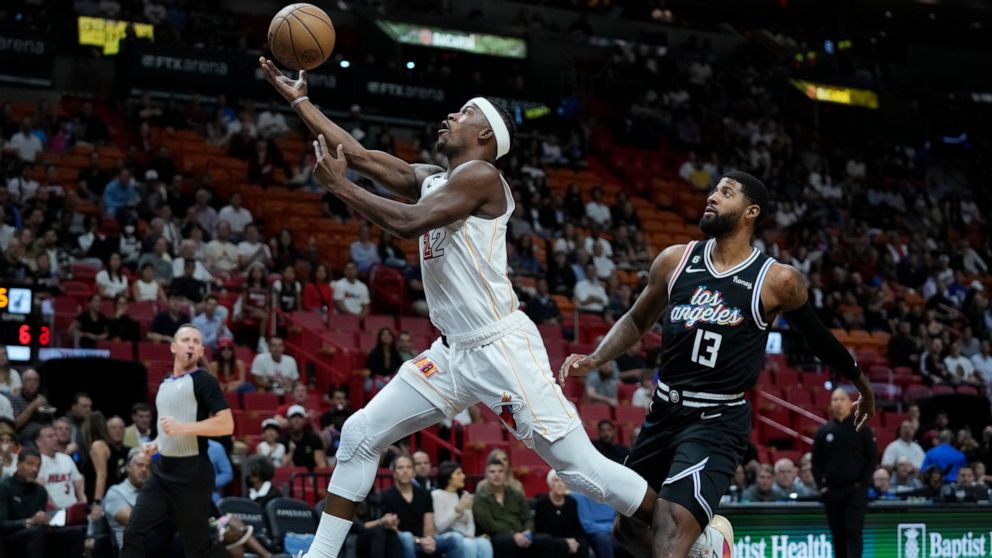 Miami Heat forward Jimmy Butler (22) goes up for a shot against Los Angeles Clippers forward Paul George (13) during the first half of an NBA basketball game, Thursday, Dec. 8, 2022, in Miami. (AP Photo/Wilfredo Lee)