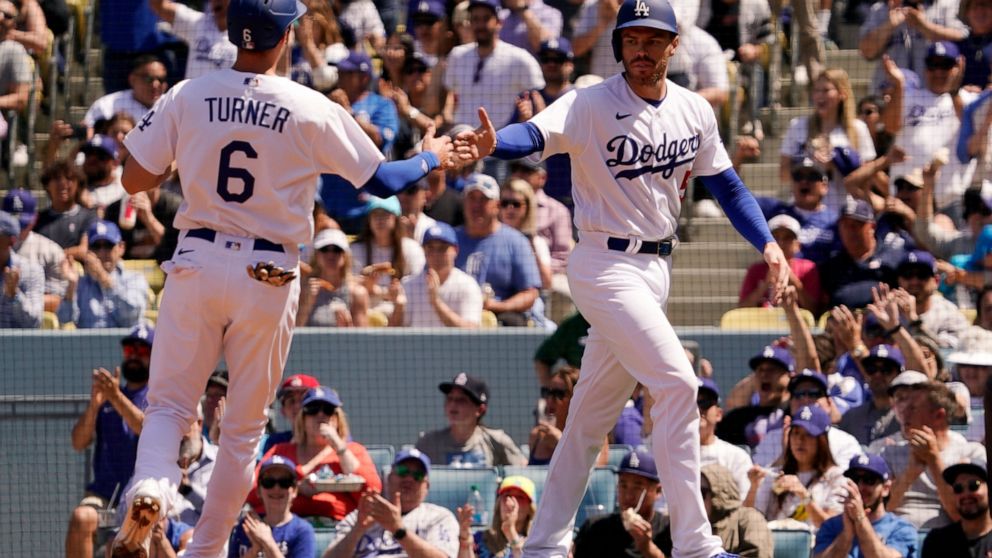 Los Angeles Dodgers' Trea Turner, left, and Freddie Freeman congratulate each other after they scored on a double by Max Muncy during the fourth inning of a baseball game against the Cincinnati Reds Sunday, April 17, 2022, in Los Angeles. (AP Photo/M