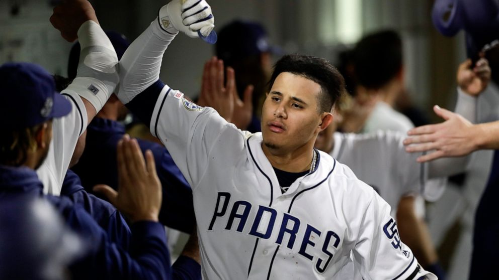 San Diego Padres' Manny Machado, center, reacts after hitting a grand slam during the sixth inning of a baseball game against the Philadelphia Phillies, Monday, June 3, 2019, in San Diego. (AP Photo/Gregory Bull)