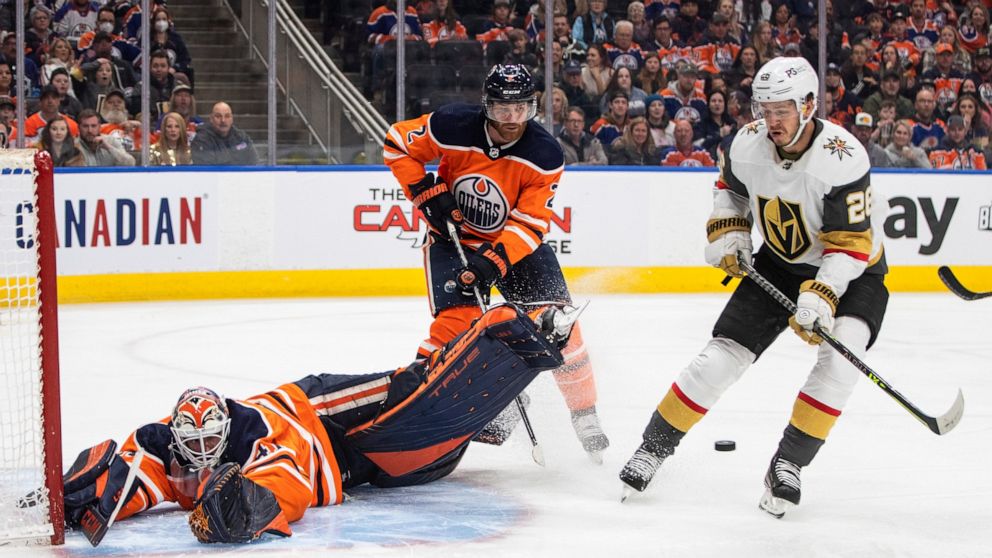 Vegas Golden Knights' Mattias Janmark (26) is stopped by Edmonton Oilers' goalie Mike Smith (41) as Duncan Keith (2) defends during the first period of an NHL hockey game Saturday, April 16, 2022 in Edmonton, Alberta. (Jason Franson/The Canadian Pres