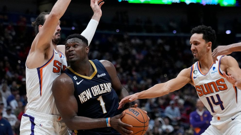 New Orleans Pelicans forward Zion Williamson (1) drives to the basket between Phoenix Suns forward Dario Saric and guard Damion Lee (10) in the second half of an NBA basketball game in New Orleans, Sunday, Dec. 11, 2022. The Pelicans won 129-124. (AP