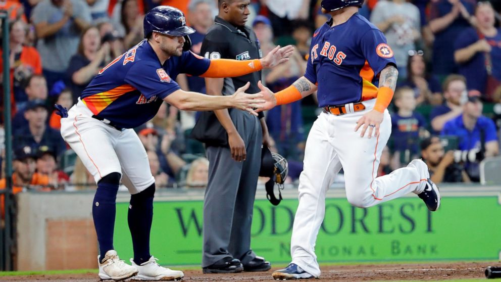 Houston Astros' Chas McCormick, left, and Christian Vazquez, right, celebrate as they both scored on an RBI-double by Jose Altuve during the second inning of a baseball game against the Oakland Athletics, Sunday, Aug. 14, 2022, in Houston. (AP Photo/