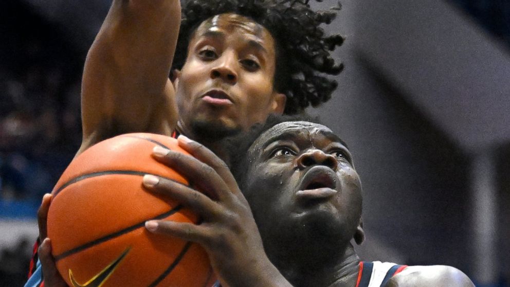 Connecticut forward Adama Sanogo (21) looks to shoot as Delaware State forward Kyle Johnson, top, defends during the second half of an NCAA college basketball game, Sunday, Nov. 20, 2022, in Hartford, Conn. (AP Photo/Jessica Hill)