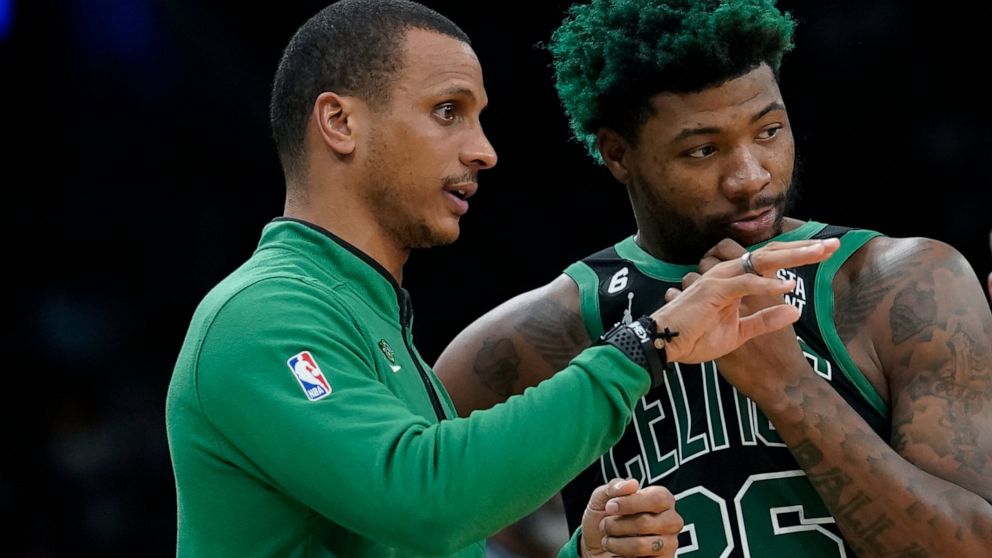 Boston Celtics interim head coach Joe Mazzulla, left, speaks with guard Marcus Smart, right, in the first half of an NBA basketball game against the Washington Wizards, Sunday, Oct. 30, 2022, in Boston. (AP Photo/Steven Senne)