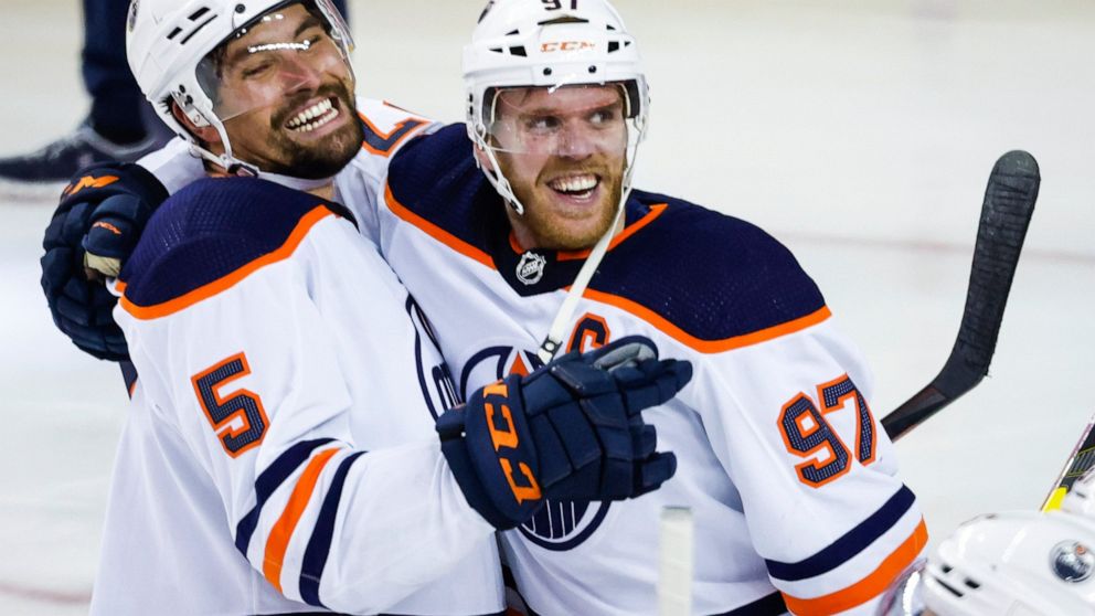 Edmonton Oilers center Connor McDavid, right, celebrates his goal against the Calgary Flames with defenseman Cody Ceci in overtime in Game 5 of an NHL hockey second-round playoff series Thursday, May 26, 2022, in Calgary, Alberta. (Jeff McIntosh/The 