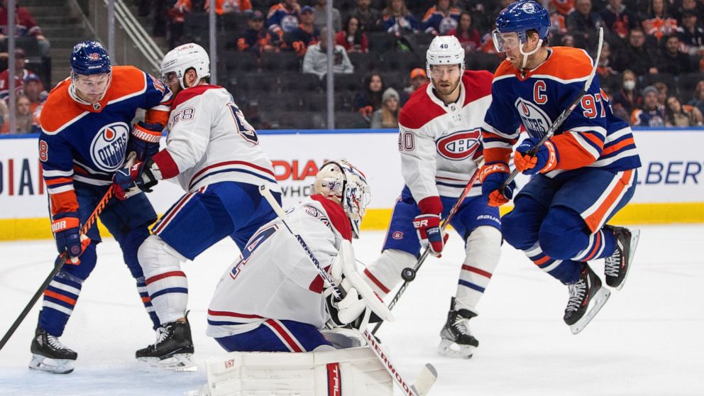 Montreal Canadiens goalie Jake Allen (34) makes the save as Edmonton Oilers' Connor McDavid (97) jumps during the second period of an NHL hockey game, Saturday, Dec. 3, 2022 in Edmonton, Alberta. (Jason Franson/The Canadian Press via AP)