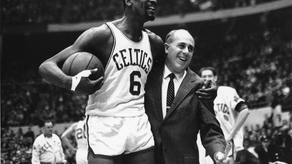 FILE - Bill Russell, left, star of the Boston Celtics is congratulated by coach Arnold "Red" Auerbach after scoring his 10,000th point in the NBA game against the Baltimore Bullets in Boston Garden on Dec. 12, 1964. The NBA great Bill Russell has die