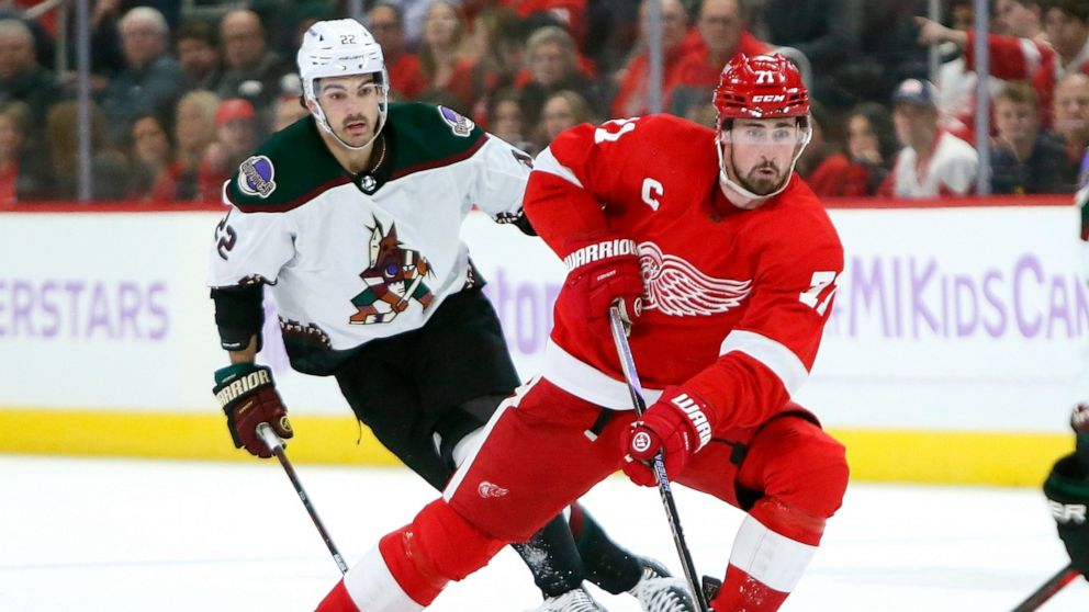 Detroit Red Wings center Dylan Larkin (71) takes the puck past Arizona Coyotes center Jack McBain (22) during the first period of an NHL hockey game Friday, Nov. 25, 2022, in Detroit. (AP Photo/Duane Burleson)