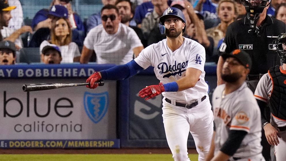 Los Angeles Dodgers' Joey Gallo, left, hits a three-run home run as San Francisco Giants relief pitcher Jarlin Garcia, right, watches during the second inning of a baseball game Tuesday, Sept. 6, 2022, in Los Angeles. (AP Photo/Mark J. Terrill)