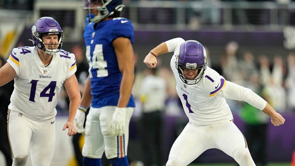 Minnesota Vikings place kicker Greg Joseph (1) celebrates in front of New York Giants cornerback Nick McCloud (44) after kicking 61-yard field on the final play of an NFL football game, Saturday, Dec. 24, 2022, in Minneapolis. The Vikings won 27-24. 