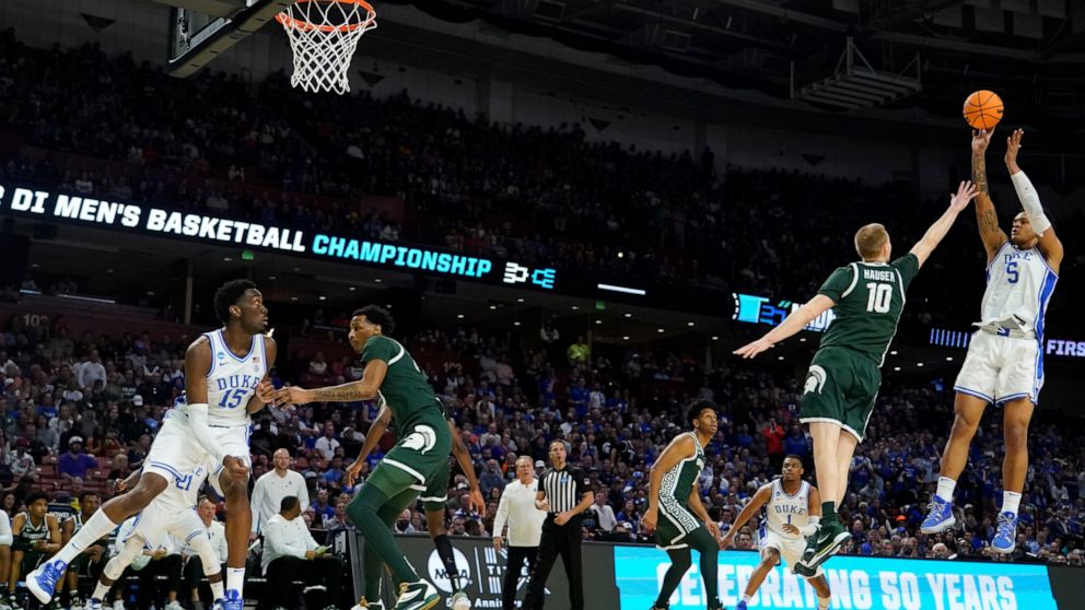 Duke forward Paolo Banchero shoots over Michigan State forward Joey Hauser during the first half of a college basketball game in the second round of the NCAA tournament on Sunday, March 20, 2022, in Greenville, S.C. (AP Photo/Chris Carlson)