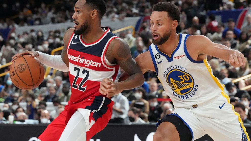 Washington Wizards' Monte Morris, left, plays against Golden State Warriors' Stephen Curry during their preseason NBA basketball game, Friday, Sept. 30, 2022, at Saitama Super Arena, in Saitama, north of Tokyo. (AP Photo/Eugene Hoshiko)