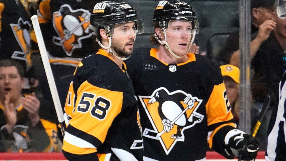 Pittsburgh Penguins' Kris Letang (58) celebrates his goal with Chad Ruhwedel during the second period of an NHL hockey game against the Columbus Blue Jackets in Pittsburgh, Friday, April 29, 2022. (AP Photo/Gene J. Puskar)