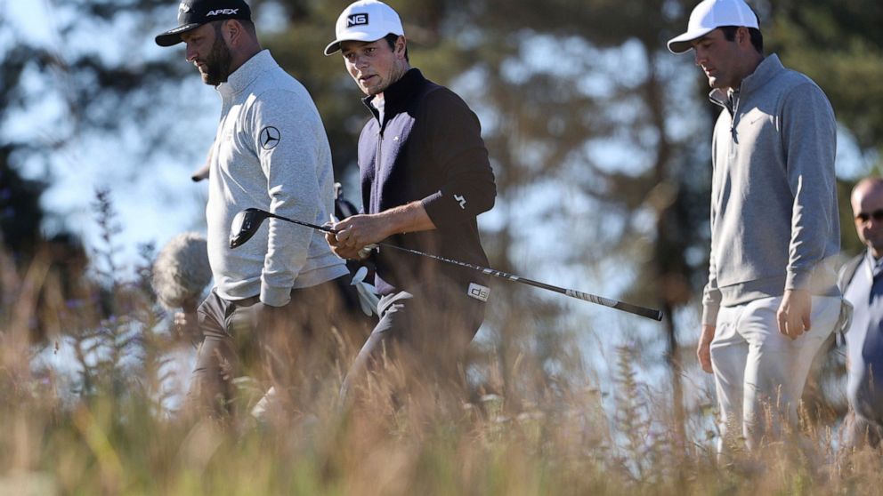 Norway's Viktor Hovland, center, and Spain's Jon Rahm, left, during day one of the Scottish Open at The Renaissance Club, North Berwick, Scotland, Thursday July 7, 2022. (Steve Welsh/PA via AP)