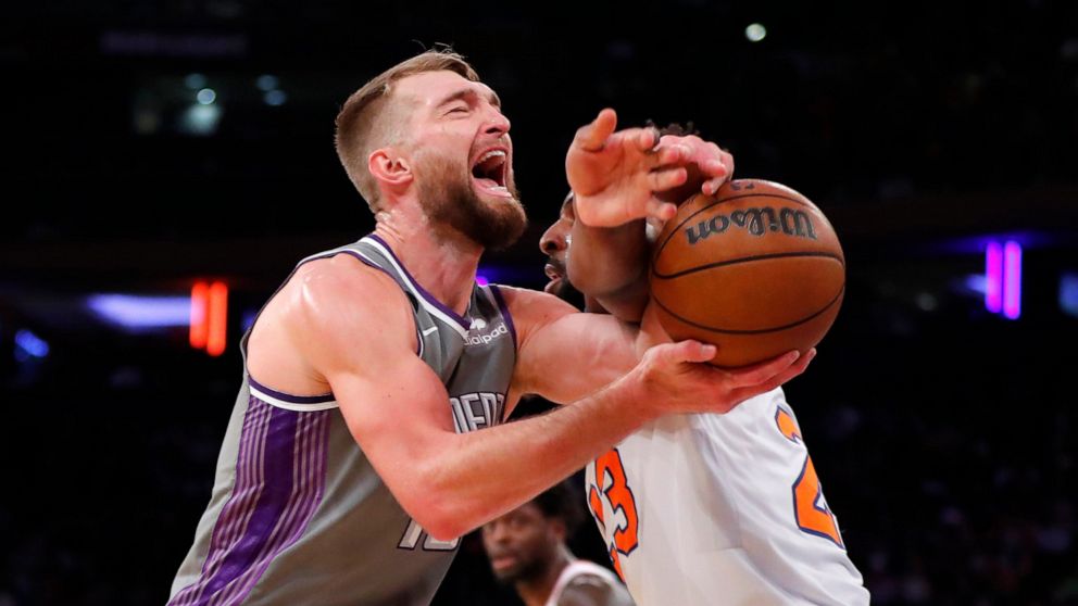 Sacramento Kings forward Domantas Sabonis is fouled by New York Knicks center Mitchell Robinson (23) during the first half of an NBA basketball game, Sunday, Dec. 11, 2022, in New York. (AP Photo/Noah K. Murray)