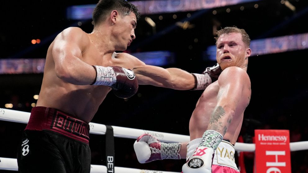 Dmitry Bivol, left, of Kyrgyzstan, throws a punch against Canelo Alvarez, of Mexico, during a light heavyweight title fight, Saturday, May 7, 2022, in Las Vegas. (AP Photo/John Locher)