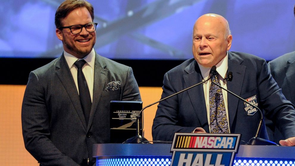 FILE - Hall of Fame inductee Bruton Smith entertains the crowd as his son, Marcus Smith, left, looks on during NASCAR Hall of Fame Induction ceremonies in Charlotte, N.C., Saturday, Jan. 23, 2016. Bruton Smith, a North Carolina native and entrepreneu