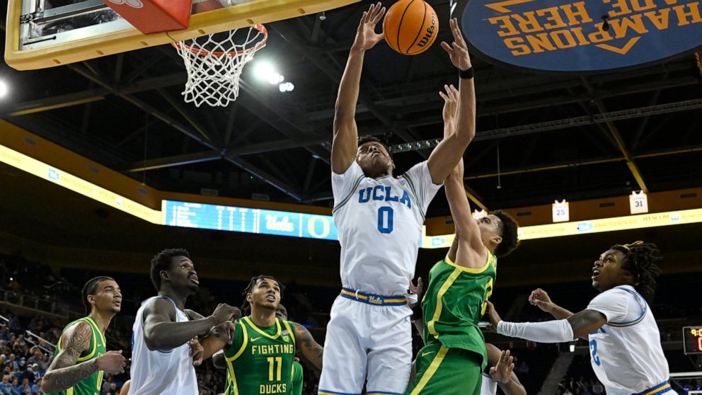 UCLA guard Jaylen Clark (0) and Oregon guard Will Richardson battle for a rebound during the first half of an NCAA college basketball game Sunday, Dec. 4, 2022, in Los Angeles. (AP Photo/John McCoy)