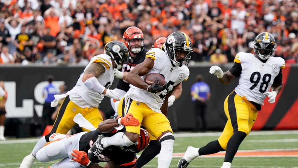 Pittsburgh Steelers cornerback Ahkello Witherspoon is tackled by Cincinnati Bengals running back Samaje Perine after an interception during the second half of an NFL football game, Sunday, Sept. 11, 2022, in Cincinnati. (AP Photo/Joshua A. Bickel)