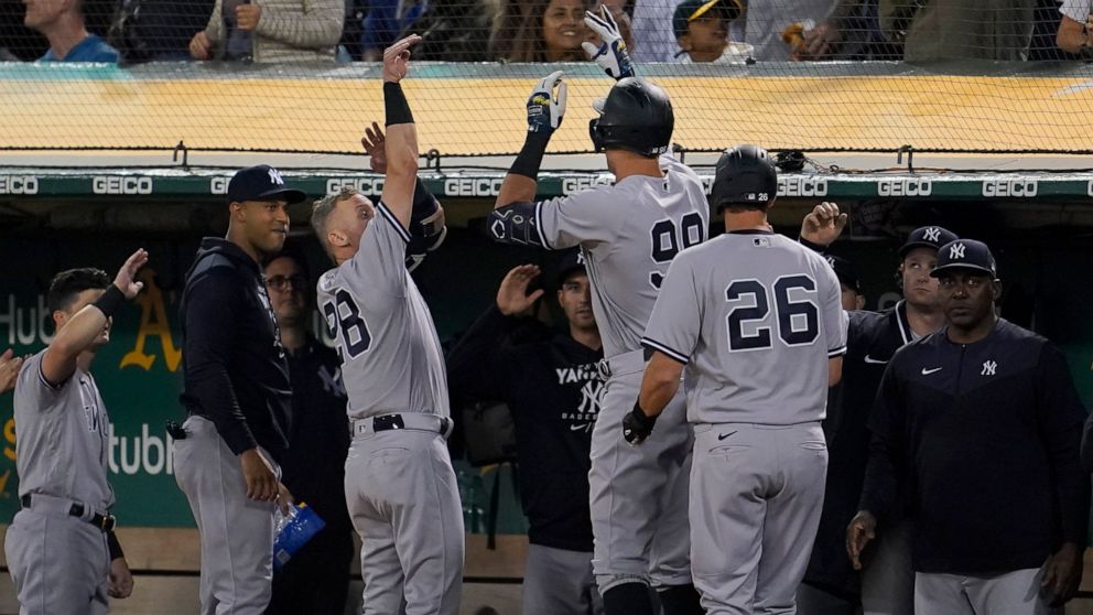 New York Yankees' Aaron Judge, middle, celebrates with teammates after hitting a three-run home run against the Oakland Athletics during the fifth inning of a baseball game in Oakland, Calif., Friday, Aug. 26, 2022. (AP Photo/Jeff Chiu)