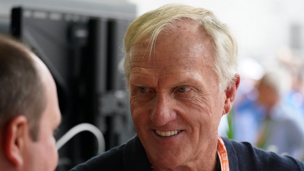 Professional golfer Greg Norman walks through the pit area during the third practice session for the Formula One Miami Grand Prix auto race at the Miami International Autodrome, Saturday, May 7, 2022, in Miami Gardens, Fla. (AP Photo/Darron Cummings)