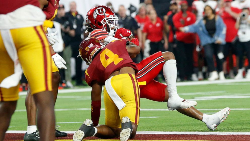 Utah wide receiver Jaylen Dixon, top right, pushes past Southern California defensive back Max Williams (4) for a touchdown during the first half of the Pac-12 Conference championship NCAA college football game Friday, Dec. 2, 2022, in Las Vegas. (AP