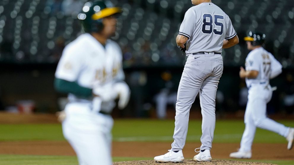 New York Yankees relief pitcher Greg Weissert (85) looks toward home plate after walking Oakland Athletics' Tony Kemp, foreground, to load the bases during the seventh inning of a baseball game in Oakland, Calif., Thursday, Aug. 25, 2022. (AP Photo/G
