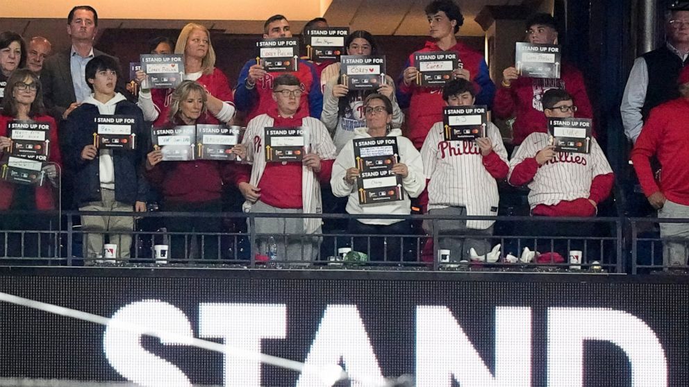 First Lady Jill Biden, third from left in front, hold signs for Stand Up To Cancer between the fifth and sixth innings in Game 4 of baseball's World Series between the Houston Astros and the Philadelphia Phillies on Wednesday, Nov. 2, 2022, in Philad