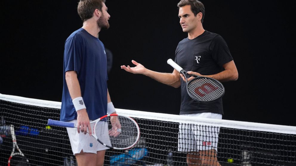 Switzerland's Roger Federer, right, chats with Cameron Norris, of Great Britain during a training session ahead of the Laver Cup tennis tournament at the O2 in London, Wednesday, Sept. 21, 2022. Federer appeared earlier at a news conference to discus