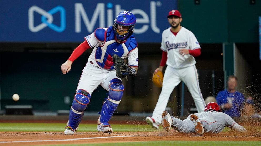 Texas Rangers catcher Jonah Heim waits on the throw as Los Angeles Angels' Luis Rengifo scores on a Mike Trout two-run double in the third inning of a baseball game in Arlington, Texas, Thursday, Sept. 22, 2022. Rangers starting pitcher Martin Perez,