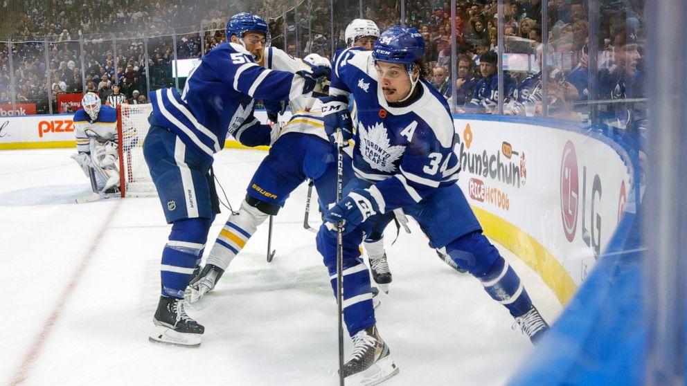 Toronto Maple Leafs' Auston Matthews (34) moves the puck around the boards during the second period of an NHL hockey game against the Buffalo Sabres in Toronto on Saturday, Nov. 19, 2022. (Cole Burston/The Canadian Press via AP)