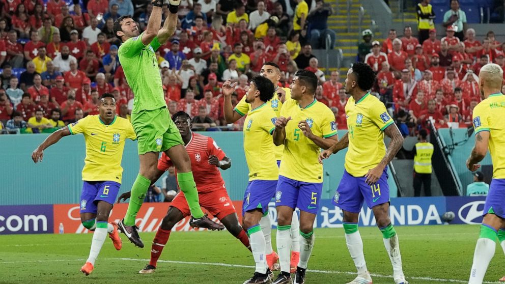 Brazil's goalkeeper Alisson, top, clears the ball during the World Cup group G soccer match between Brazil and Switzerland at the Stadium 974 in Doha, Qatar, Monday, Nov. 28, 2022. (AP Photo/Hassan Ammar)