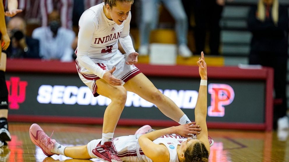 Indiana guard Ali Patberg (14) celebrates on the floor with guard Nicole Cardano-Hillary (4) after being fouled on a shot by Princeton in the first half of a college basketball game in the second round of the NCAA tournament in Bloomington, Ind., Mon
