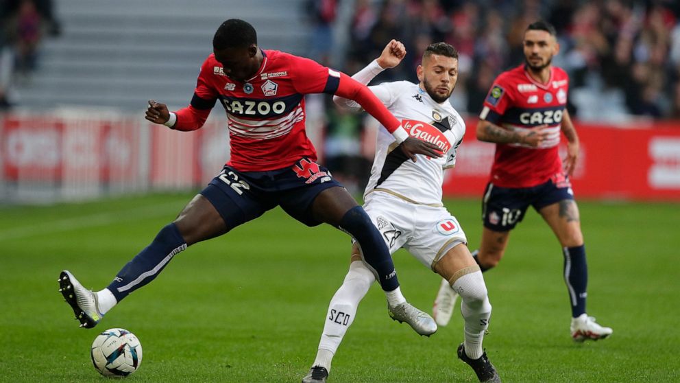 Lille's Timothy Weah, left, avoids a tackle by Angers' Farid el Melali during the French League One match Lille against Angers at the Pierre Mauroy stadium Sunday, Nov. 13, 2022 in Lille, northern France. (AP Photo/Michel Spingler)