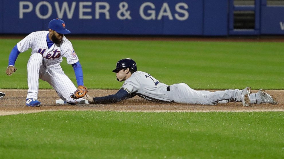 Milwaukee Brewers' Christian Yelich, right, beats the tag by New York Mets shortstop Amed Rosario to steal second base during the first inning of a baseball game Friday, April 26, 2019, in New York. (AP Photo/Frank Franklin II)