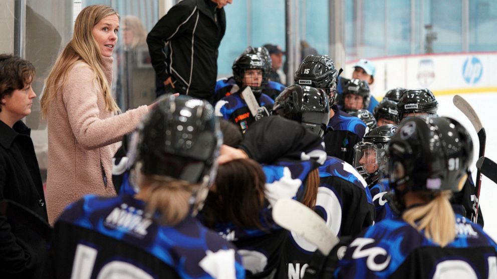 Minnesota Whitecaps coach Ronda Engelhardt talks with players on the bench during a hockey game against the Metropolitan Riveters in St. Paul, Minn., Saturday, Oct. 12, 2019. The Nashville Predators have hired their first female scout with Ronda Enge