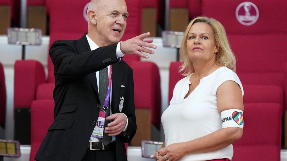 German Football Federation (DFB) President Bernd Neuendorf, left, talks to German Interior Minister Nancy Faeser, right, wearing the One Love armband on the tribune prior to the World Cup group E soccer match between Germany and Japan, at the Khalifa