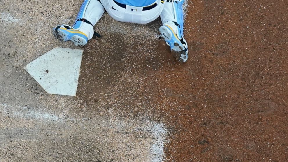 Milwaukee Brewers catcher Victor Caratini tags out Pittsburgh Pirates Kevin Newman at home to end the ninth inning of a baseball game Friday, July 8, 2022, in Milwaukee. (AP Photo/Morry Gash)