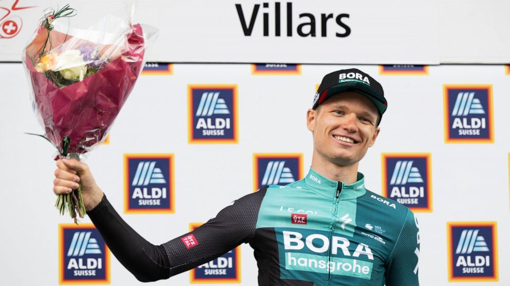 Aleksandr Vlasov, from Russia, celebrates on podium after winning the fifth and last stage, a 15,8 km race against the clock between Aigle and Villars at the 75th Tour de Romandie UCI ProTour cycling race in Villars, Switzerland, Sunday, May 1, 2022.
