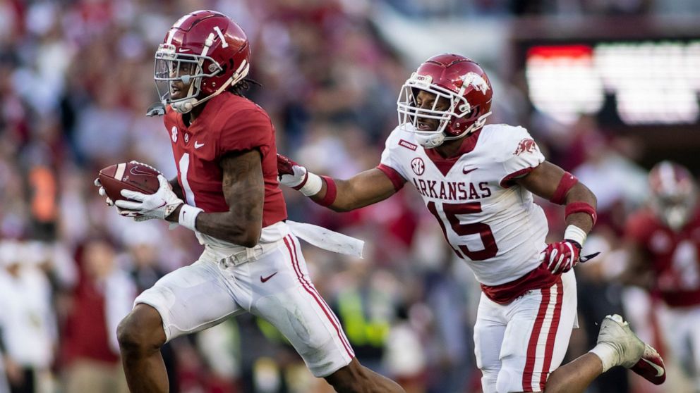 Alabama wide receiver Jameson Williams (1) runs by Arkansas defensive back Simeon Blair (15) with a touchdown reception during the first half of an NCAA college football game Saturday, Nov. 20, 2021, in Tuscaloosa, Ala. (AP Photo/Vasha Hunt)