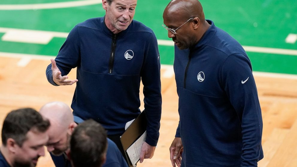 Golden State Warriors assistant coach Kenny Atkinson, left, talks with assistant coach Mike Brown during a timeout during the first quarter of Game 4 of basketball's NBA Finals against the Boston Celtics, Friday, June 10, 2022, in Boston. (AP Photo/S