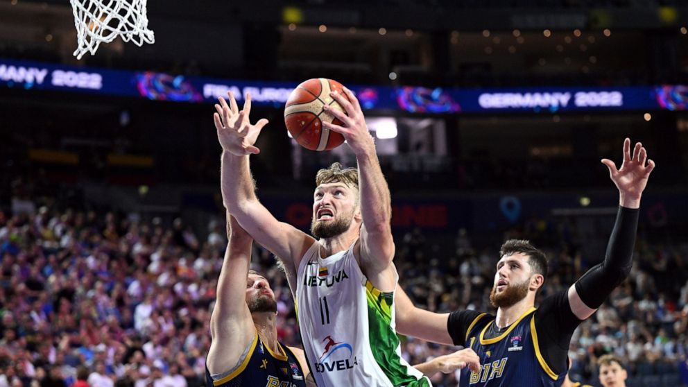 Lithuania's Domantas Sabonis, center, is challenged by Bosnia-Herzegovina's Miralem Halilovic, left, and Jusuf Nurkic, right, during their Eurobasket group B basketball match in Cologne, Germany, Wednesday, Sept. 7, 2022. (Federico Gambarini/dpa via AP)