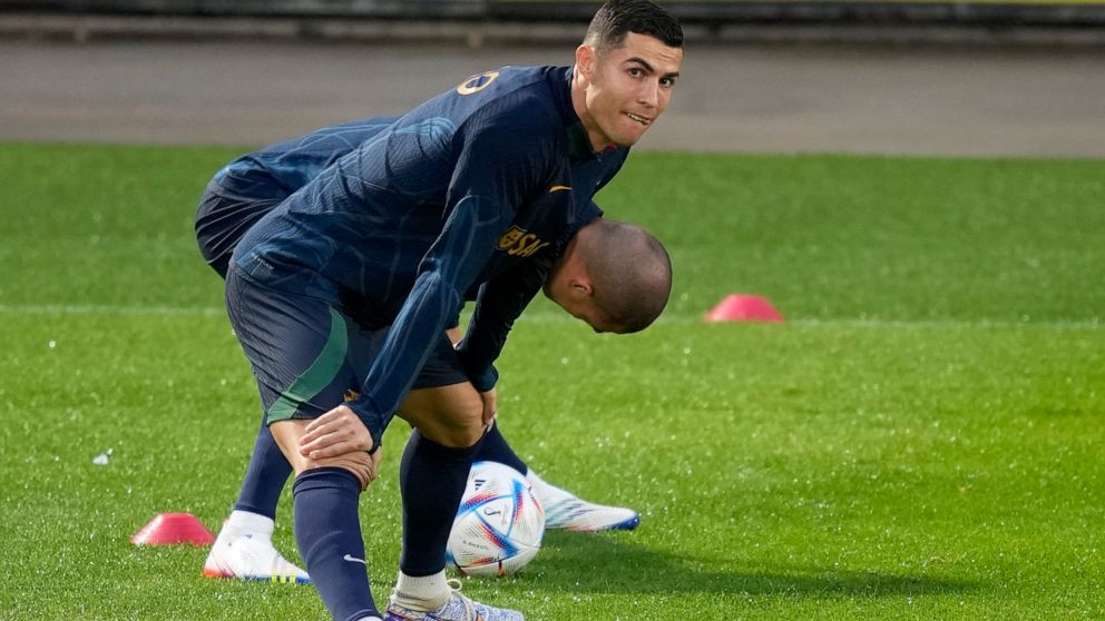 Cristiano Ronaldo stretches with teammate Pepe, in the background, during a Portugal soccer team training session in Oeiras, outside Lisbon, Monday, Nov. 14, 2022. Portugal will play Nigeria Thursday in a friendly match in Lisbon before departing to 