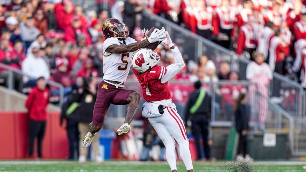 Minnesota wide receiver Dylan Wright (5) makes a reception over Wisconsin cornerback Jay Shaw (1) during the first half of an NCAA college football game Saturday, Nov. 26, 2022, in Madison, Wis. (AP Photo/Andy Manis)