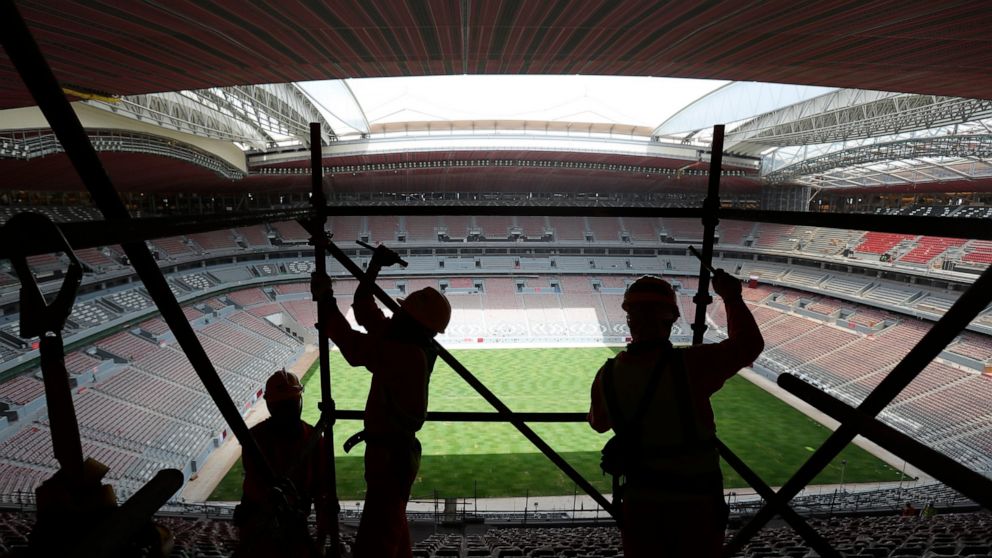 FILE - Laborers remove scaffolding at the Al Bayt stadium in Al Khor, Qatar, about 50 kilometers (30 miles) north of Doha, Monday, April 29, 2019. With just days to go before Qatar hosts the World Cup, rights groups fear that a window for addressing 