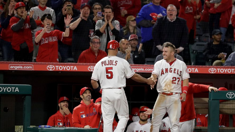 Los Angeles Angels' Albert Pujols returns to the dugout after scoring on a double by Kole Calhoun during the fifth inning of the team's baseball game against the Toronto Blue Jays in Anaheim, Calif., Wednesday, May 1, 2019. (AP Photo/Chris Carlson)
