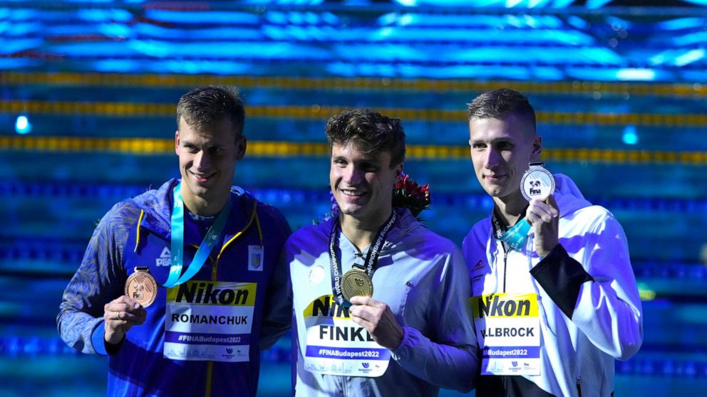 Mykhailo Romanchuk of Ukraine, Bobby Finke of the United States, Florian Wellbrock of Germany, from left to right, pose with their medals after the Men 800m Freestyle final at the 19th FINA World Championships in Budapest, Hungary, Tuesday, June 21, 