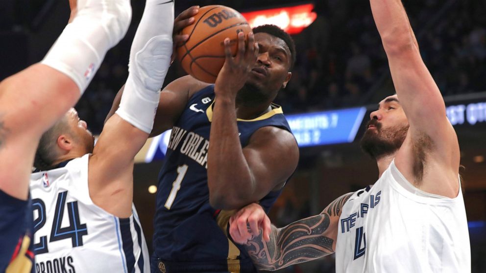 New Orleans Pelicans forward Zion Williamson (1) shoots while defended by Memphis Grizzlies guard Dillon Brooks (24) and center Steven Adams (4) during the first half of an NBA basketball game Saturday, Dec. 31, 2022, in Memphis, Tenn. (AP Photo/Nikk