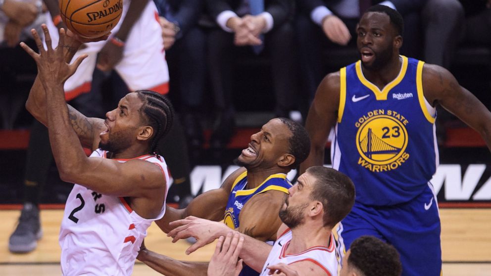 Toronto Raptors forward Kawhi Leonard (2) drives to the net past Golden State Warriors guard Andre Iguodala, center, during the first half of Game 2 of basketball’s NBA Finals, Sunday, June 2, 2019, in Toronto. (Nathan Denette/The Canadian Press via AP)